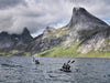 A group of two double seater neris kayaks paddling along the norwegian coast.