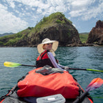 Person in a kayak with a scenic background of rocks and water
